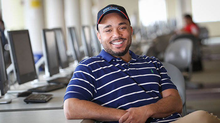 Adult student sitting in front of a computer in a computer lab. 