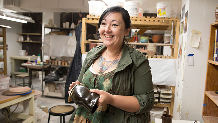 Smiling Missouri State student in an art studio.
